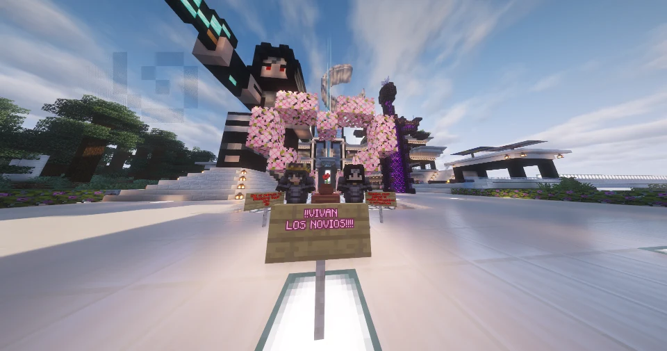 La boda de Dani y Daii: los novios bajo un arco de flores de cerezo y un cartel que dice ¡¡Vivan los novios!!